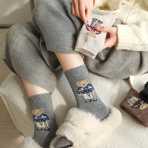 Detailed close-up of cute teddy bear pattern on thick wool blend socks in vintage colors