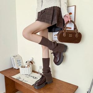 Detail showing coffee brown cable knit leg warmers paired with retro platform shoes