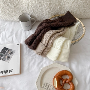 Gros plan de jambières en maille torsadée marron et beige avec texture douce détaillée