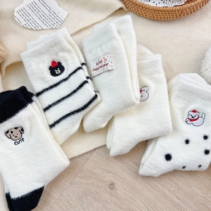 Detailed view of plush thermal socks with cute dog embroidery and holiday label
