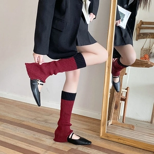 Dettaglio di scaldamuscoli in maglia a coste rosso e nero con bordo a campana JK