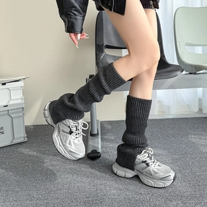 Close-up of dark grey ribbed knit leg warmers styled with sneakers for a trendy layered look
