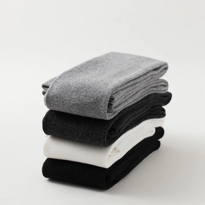 Detail of four pairs of ribbed knit over-the-knee socks in black, white, and grey tones