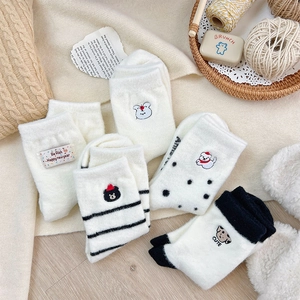Detail view of thick winter socks with cute cartoon embroidery and stripe patterns