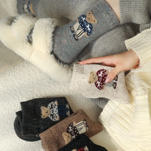 Detail of thick wool knit socks featuring cute cartoon bear patterns for winter warmth