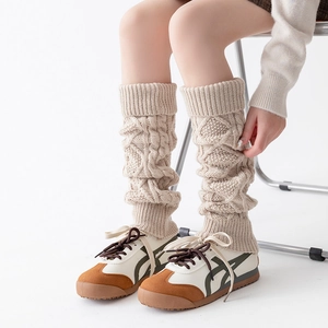 Détail du tricot torsadé crème sur les jambières avec finitions en côtes élastiques