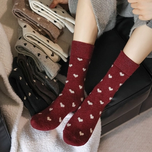 Detail of warm wool blend crew socks with white heart jacquard in burgundy and grey