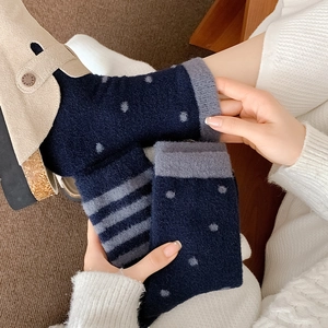 Detailed close-up of dark blue thermal fuzzy socks featuring polka dots and classic stripes