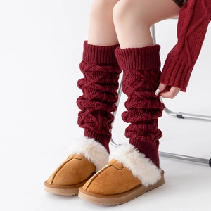 Détail de jambières en grosse maille torsadée bordeaux avec chaussons doux pour l'hiver