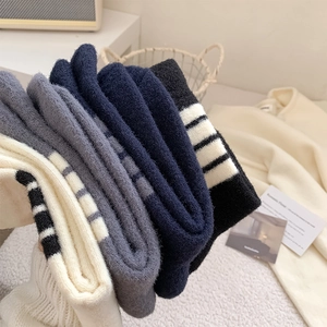 Close-up of four thick knitted striped crew socks in various colors for winter warmth