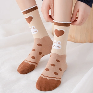 Detailed knit texture of cute rabbit and heart pattern on beige crew cotton socks