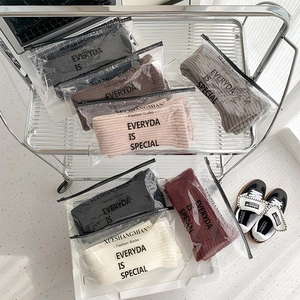 Detailed close-up of ribbed knit leg warmers in various colors with zipper packaging