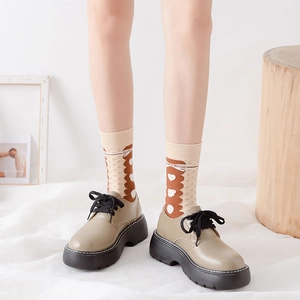 Detail of cute bear pattern socks worn with stylish khaki platform oxford shoes