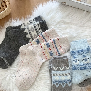 Detaillierte Nahaufnahme dicker Wollsocken mit Schneemann und geometrischen Mustern