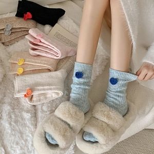 Détail de la maille côtelée et du patch cœur sur ces chaussettes douillettes en laine