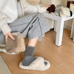 Close-up of thick knitted crew socks with plush faux mink trim and textured ribbing