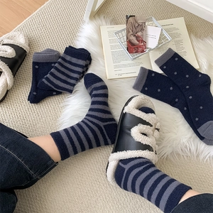 Macro detail of plush striped knit socks in navy blue and grey cozy winter home style