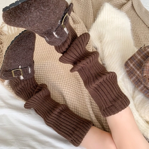 Detail showing dark coffee knitted leg warmers paired with cozy faux fur clogs