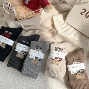 Close-up of five pairs of wool blend socks with cute bear patterns in earthy tones