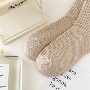 Detail of oatmeal ribbed knit leg warmers with soft texture in a minimalist aesthetic