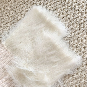 Close-up of soft pink knit fabric and white faux fur trim on warm winter crew socks