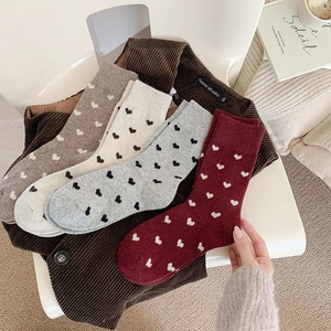 Detail view of thick winter crew socks set with heart patterns in warm autumn colors