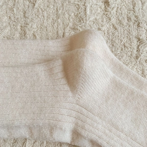 Vue détaillée des chaussettes en laine crème avec texture douce à rayures verticales