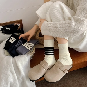 Close-up of thick striped crew socks with ribbed cuffs and khaki suede loafers