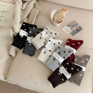 Close-up of wool socks set with heart patterns in various colors on knit fabric