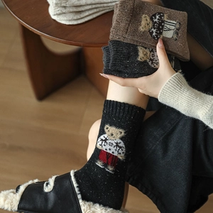 Detailed close-up of thick knitted wool socks featuring cute British style bear embroidery