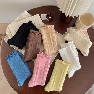 Detailed view of colorful wool socks with ruffled cuffs and vertical ribbed texture