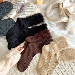 Detail of warm winter crew socks with faux fur trim and cozy ribbed knit texture
