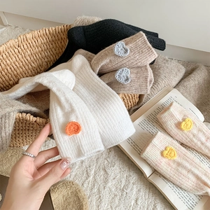 Détail de chaussettes en laine avec cœurs crochetés et texture maille dans un panier