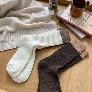 Detail of ribbed knit wool socks with contrast cuffs in cream and dark brown tones