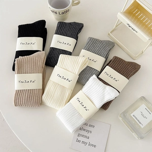 Flat lay of colorful ribbed knit crew socks with minimalist home decor aesthetics