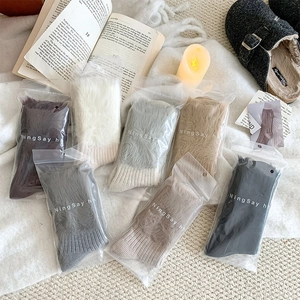 Thick knit winter socks in diverse colors shown in cozy home setting with zip packaging
