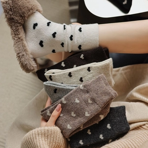 Close-up of thick wool socks with small heart patterns and soft knitted texture for winter