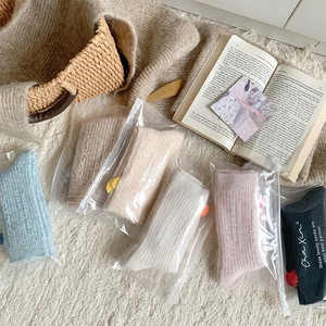 Détail de chaussettes en laine épaisses en six couleurs pastel avec texture côtelée