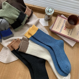 Macro detail of thick rib-knit wool socks in various color-block patterns for winter