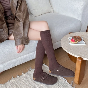 Cozy brown suede clogs with matching thick knit calf socks in a warm home setting