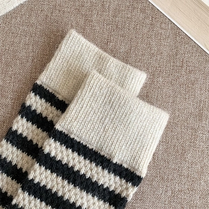 Close-up of thick striped wool socks featuring ribbed cuffs and warm knit texture