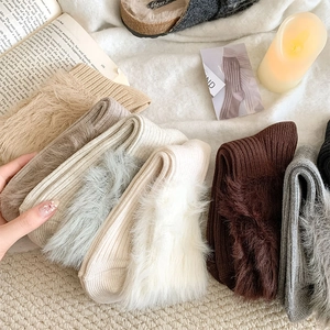 Detail of thick ribbed knit winter socks with plush faux fur lining in earth tones