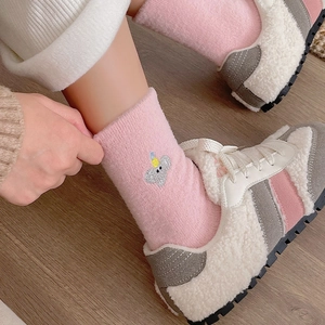 Détail de chaussettes thermiques en polaire corail rose avec broderie koala