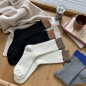 Close-up of ribbed texture wool socks with color-block cuffs in warm lifestyle setting