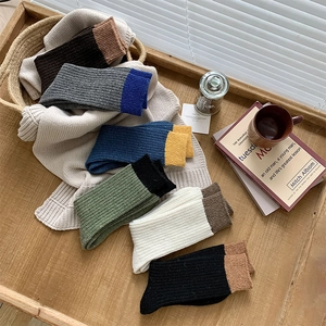 Detailed close-up of colorful ribbed wool socks in a cozy autumn-themed lifestyle display