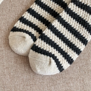 Close-up of the ribbed knit toe detail on warm black and white striped wool socks