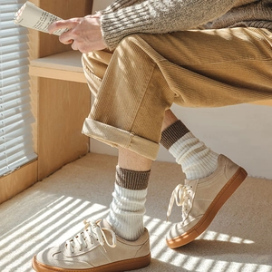 Detail of wool blend ribbed socks with contrast stripes and corduroy trousers texture