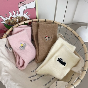 Gros plan détaillé de chaussettes en peluche avec broderie animale mignonne