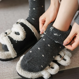 Detail of wool socks with white polka dots and sherpa slippers with metal buckles