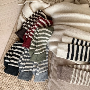 Detailed view of thick knit wool socks with retro striped and checkerboard patterns
